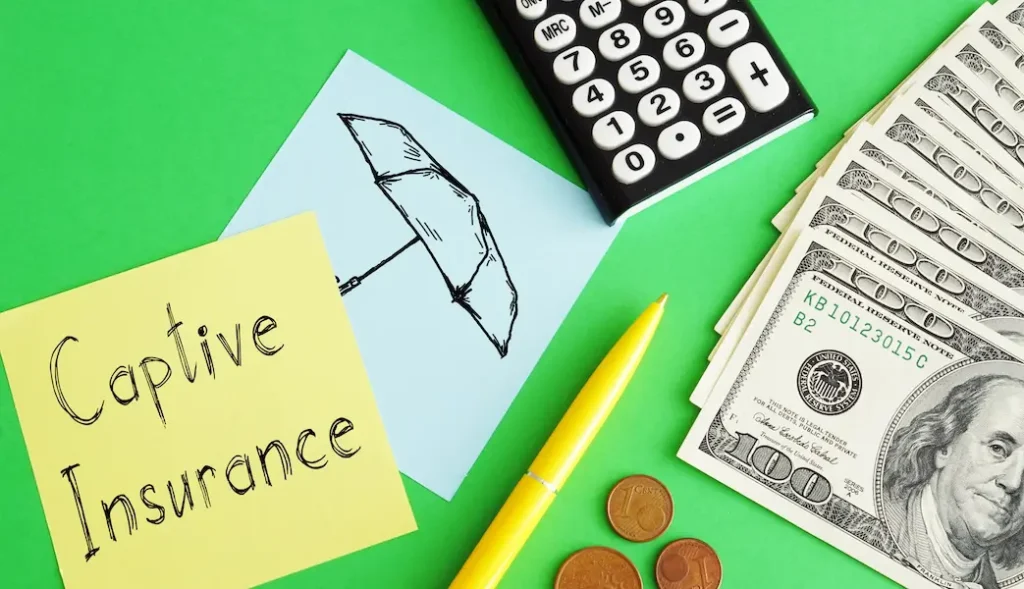 image of green table with 100 usd and a yellow post it note saying captive insurance